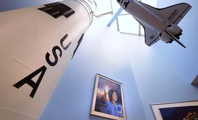 A model of the space shuttle Challenger, at right, floats above a portrait of NASA's first teacher in space Christa McAuliffe at the McAuliffe-Shepard Discovery Center, Monday, Dec. 16, 2024, in Concord, N.H. (AP Photo/Charles Krupa)