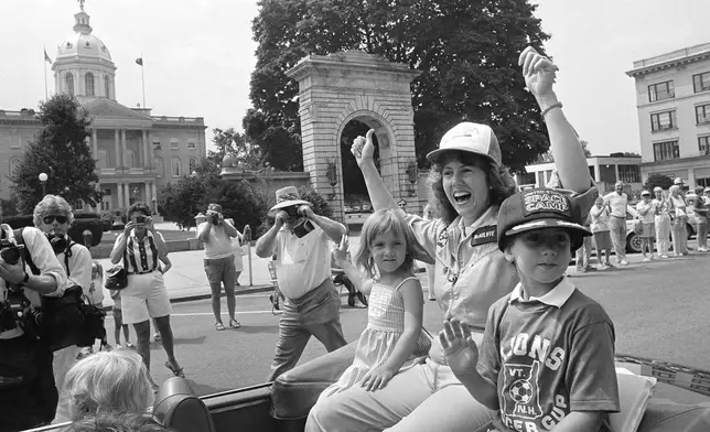 Christa McAuliffe, NASA's first teacher in space, rides with her children Caroline and Scott past the Statehouse during a parade, Saturday, July 21, 1985 in Concord, N.H. (AP Photo/Jim Cole, File)