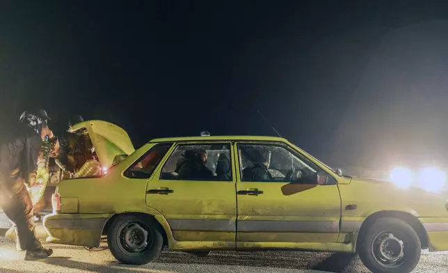 Members of the security forces of the newly formed Syrian government inspect vehicles at a security checkpoint on the Syrian border with Lebanon, Friday, Dec. 27, 2024. (AP Photo/Mosa'ab Elshamy)