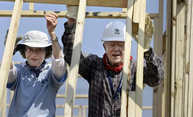 FILE - Former President Jimmy Carter, right, and former first lady Rosalynn Carter raise a wall as they help build a Habitat for Humanity house in Violet, La., May 21, 2007. The pair were working on the 1,000th Habitat for Humanity house in the Gulf Coast region since hurricane Katrina and Rita. (AP Photo/Alex Brandon, File)