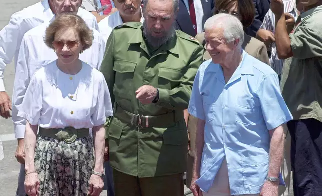 FILE - Former President Jimmy Carter, right, and his wife Rosalynn, left, meet with Cuban leader Fidel Castro at the airport in Havana, Cuba, May 17, 2002. (AP Photo/Gregory Bull, File)