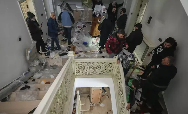 People search for belongings in the ransacked private residence of Syrian President Bashar Assad in the Malkeh district of Damascus, Syria, on Sunday, Dec. 8, 2024. (AP Photo/Hussein Malla)
