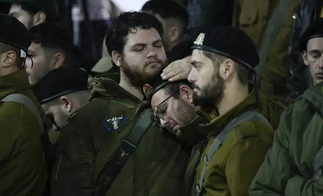 People attend the funeral of 1st Sgt. Yuval Shoham, who was killed in a combat in the Gaza Strip, at Mount Herzl military cemetery in Jerusalem, Monday, Dec. 30, 2024. (AP Photo/Matias Delacroix)