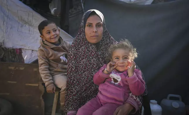 Wafaa Nasrallah poses for a portrait with her 4-year-old son Ameer and her 2-year-old daughter Ayloul at her tent at a camp for displaced Palestinians in Deir al-Balah, Gaza Strip, Dec. 28, 2024. (AP Photo/Abdel Kareem Hana)