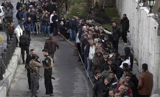 Members of Bashar Assad's army, or pro-government militia, line up to register with the newly formed Syrian government as part of an "identification and reconciliation" process in Damascus, Syria, Monday, Dec. 30, 2024. (AP Photo/Omar Sanadiki)