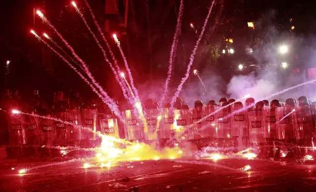 Demonstrators use firecrackers against police during a rally against the government's decision to suspend negotiations on joining the European Union for four years, outside the parliament's building in Tbilisi, Georgia, early Sunday, Dec. 1, 2024. (AP Photo/Zurab Tsertsvadze)