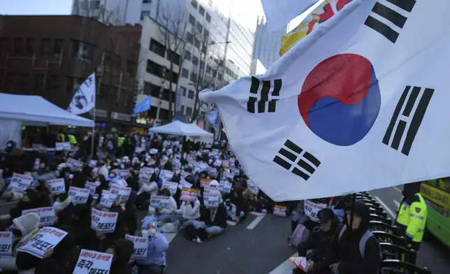 Participants hold signs during a rally calling on the Constitutional Court to dismiss the President Yoon Suk Yeol in Seoul, South Korea, Sunday, Dec. 15, 2024. The signs read "Immediately arrest." (AP Photo/Lee Jin-man)