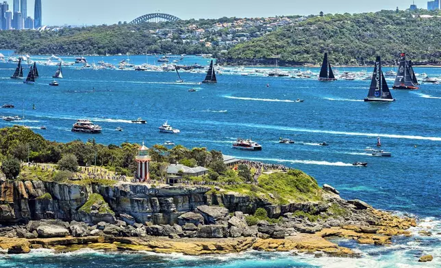 In this photo provided by Rolex, competitors sail towards the heads as they leave Sydney Harbour at the start of the Sydney to Hobart yacht race in Sydney, Thursday, Dec. 26, 2024. (Carlo Borlenghi/Rolex via AP)