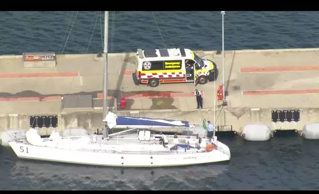 This image made from video provided by AUBC, CH9, CH7, CH9 shows sailing boat Flying Fish Arctos moored next to an ambulance at Jervis Bay, Australia, Friday, Dec. 27, 2024. (AUBC, CH9, CH7, CH9 via AP)