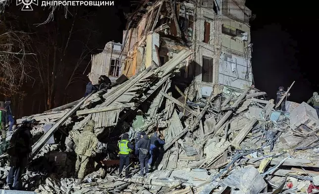 In this image provided by the Ukrainian Emergency Service on Wednesday, Dec. 25, 2024, firefighters work on a site of an apartment building destroyed by a Russian attack in Kryvyi Rih, Ukraine. (Ukrainian Emergency Service via AP)