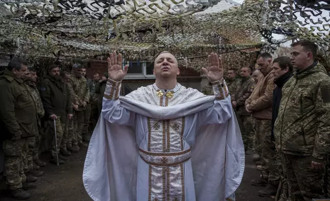 Military chaplain Yurii of 24th Mechanized Brigade holds a church service for infantry unit during Christmas near the frontline town of Chasiv Yar, Donetsk region, Ukraine, Wednesday Dec. 25, 2024. (AP Photo/Evgeniy Maloletka)