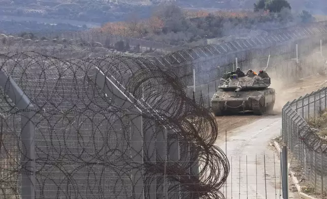 An Israeli army tank maneuvers near the so-called Alpha Line that separates the Israeli-annexed Golan Heights from Syria, in the town of Majdal Shams, Wednesday, Dec. 11, 2024. (AP Photo/Matias Delacroix)