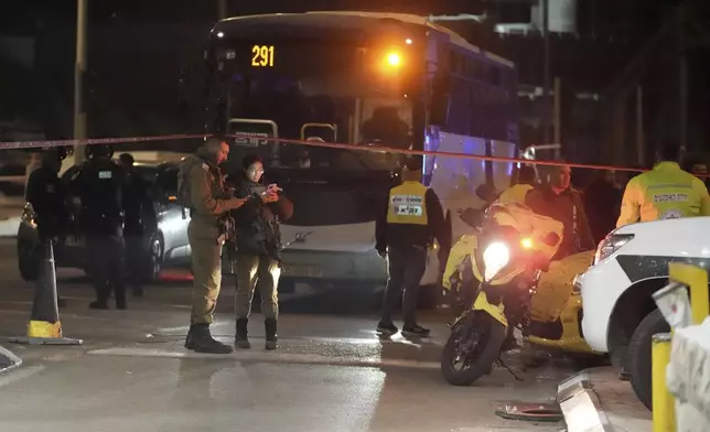 Israeli security forces work at the scene of a shooting attack on a bus near the West Bank town of Beit Jala, early Thursday, Dec. 12, 2024. (AP Photo/Mahmoud Illean)