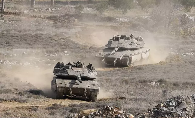 Israeli tanks maneuver next to the security fence near the so-called Alpha Line that separates the Israeli-annexed Golan Heights from Syria, in the town of Majdal Shams, Wednesday, Dec. 11, 2024. (AP Photo/Matias Delacroix)