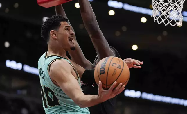 Charlotte Hornets guard Josh Green, left, makes a basket around Chicago Bulls forward Jalen Smith, right, during the first half of an NBA basketball game Friday, Dec. 13, 2024, in Chicago. (AP Photo/Erin Hooley)