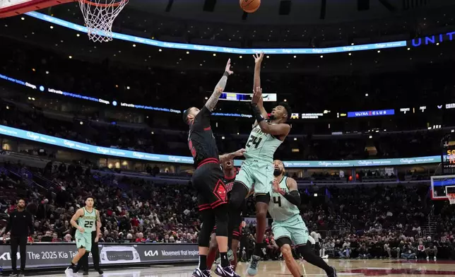 Chicago Bulls guard Lonzo Ball, center left, grabs the jersey of Charlotte Hornets forward Brandon Miller, center right, who attempts to shoot during the first half of an NBA basketball game Friday, Dec. 13, 2024, in Chicago. (AP Photo/Erin Hooley)