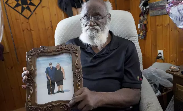 Kenny Pollard, 75, holds a photo in his home from a vacation that he and his wife, Elizabeth, took to Clearwater Beach, Fla., approximately 10 years ago. (AP Photo/Matt Freed)