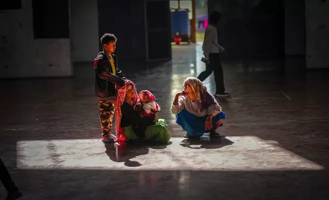 A Meitei family sits in a relief camp in Imphal, Manipur, Monday, Dec. 16, 2024. (AP Photo/Anupam Nath)