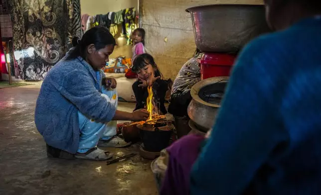 A Kuki tribal woman lights fire to prepare food in a relief camp in Kangpokpi, Manipur, Sunday, Dec. 15, 2024. (AP Photo/Anupam Nath)