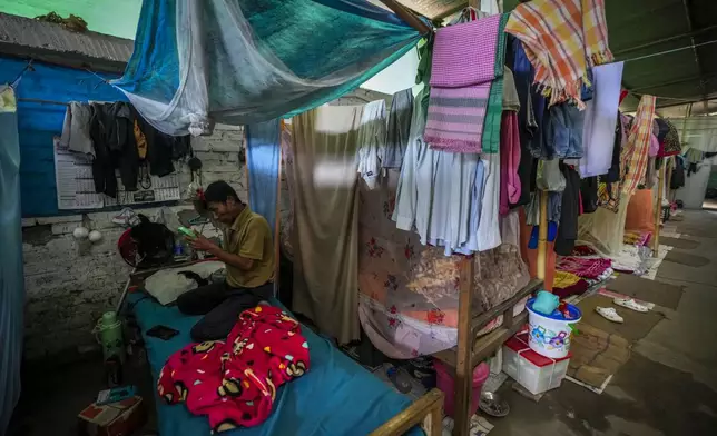 A Meitei man combs his hair in a relief camp in Imphal, Manipur, Monday, Dec. 16, 2024. (AP Photo/Anupam Nath)