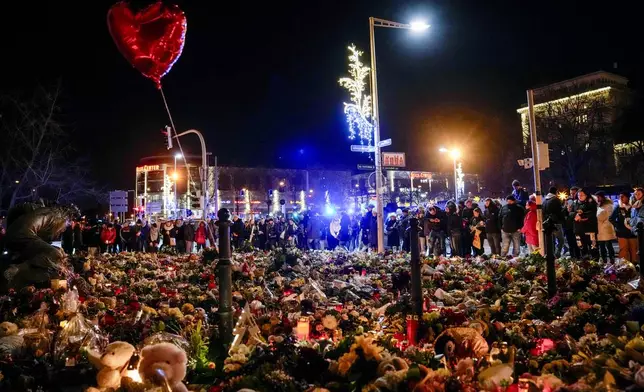 People attend an AfD election campaign in near the Christmas Market in Magdeburg, Germany, Monday, Dec. 23, 2024. (AP Photo/Ebrahim Noroozi)