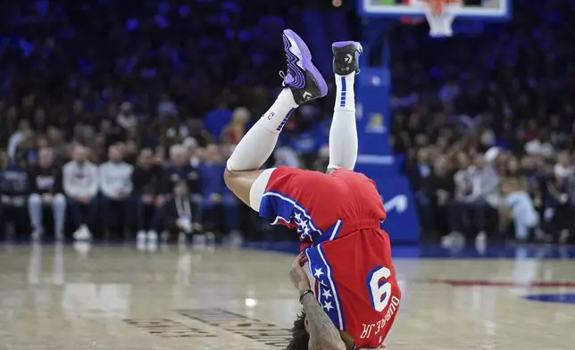 Philadelphia 76ers' Kelly Oubre Jr. tumbles after being fouled during the first half of an NBA basketball game against the Charlotte Hornets, Friday, Dec. 20, 2024, in Philadelphia. (AP Photo/Matt Slocum)