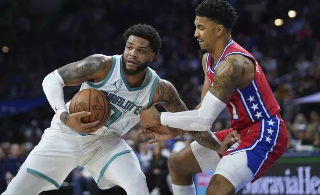 Charlotte Hornets' Miles Bridges, left, tries to get away from Philadelphia 76ers' KJ Martin during the first half of an NBA basketball game, Friday, Dec. 20, 2024, in Philadelphia. (AP Photo/Matt Slocum)