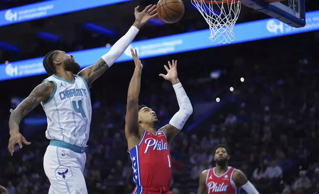 Charlotte Hornets' Nick Richards, left, reaches for a rebound over Philadelphia 76ers' KJ Martin during the first half of an NBA basketball game, Friday, Dec. 20, 2024, in Philadelphia. (AP Photo/Matt Slocum)