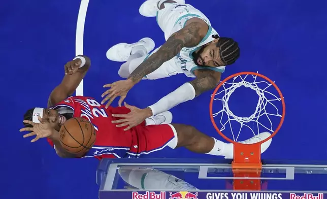 Philadelphia 76ers' Guerschon Yabusele, left, goes up for a shot against Charlotte Hornets' Nick Richards during the first half of an NBA basketball game, Friday, Dec. 20, 2024, in Philadelphia. (AP Photo/Matt Slocum)