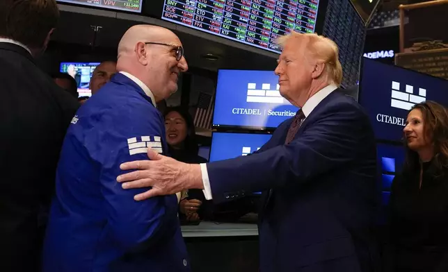 President-elect Donald Trump, with Lynn Martin, President NYSE, right, is greeted by trader Peter Giacchi, as he walks the floor of the New York Stock Exchange, Thursday, Dec. 12, 2024, in New York. (AP Photo/Alex Brandon)