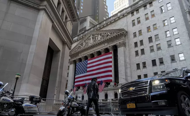 An NYPD officer walks outside of the New York Stock Exchange, Thursday, Dec. 12, 2024, in New York. (AP Photo/Julia Demaree Nikhinson)