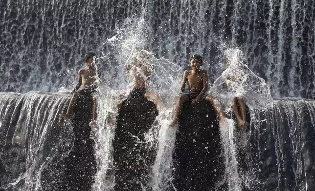 Residents bathe in a dam of Unda River in Klungkung, Bali, Indonesia, March 19, 2024. (AP Photo/Firdia Lisnawati)