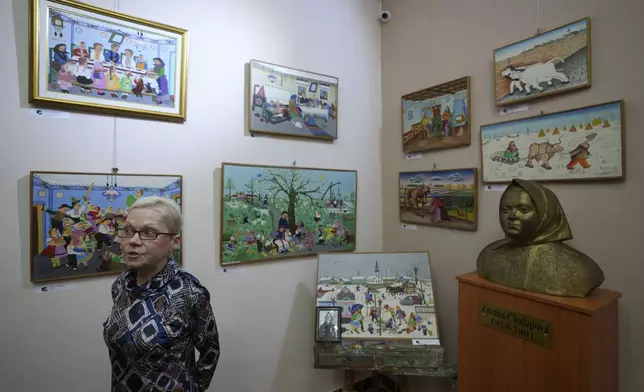 Ana Zolnaj Barca, head of the Gallery of naive art speaks about various paintings in the village of Kovacica, Serbia, Thursday, Nov. 28, 2024. (AP Photo/Darko Vojinovic)