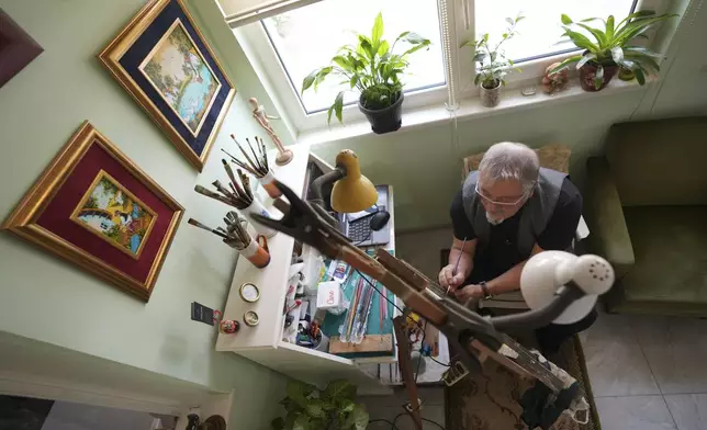 Stefan Varga paints in his room in the village of Kovacica, Serbia, Thursday, Nov. 28, 2024. (AP Photo/Darko Vojinovic)