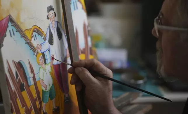 Stefan Varga paints in his room in the village of Kovacica, Serbia, Thursday, Nov. 28, 2024. (AP Photo/Darko Vojinovic)