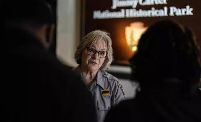 National Park employee Mary Anne Robbins speaks to guests of the Jimmy Carter National Historical Park, Monday, Dec. 30, 2024, in Plains, Ga. Former President Carter died Sunday at the age of 100. (AP Photo/Mike Stewart)