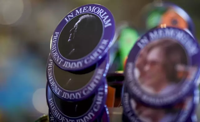 An In Memorium button for former President Jimmy Carter is seen inside the Plains Trading Post, Monday, Dec. 30, 2024, in Plains, Ga. Former President Jimmy Carter died Sunday at the age of 100. (AP Photo/Mike Stewart)