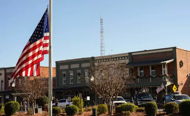 A flag flies at half-staff on main street in the aftermath of former President Jimmy Carter's death, Monday, Dec. 30, 2024, in Plains, Ga. Carter died Sunday at the age of 100.(AP Photo/Mike Stewart)