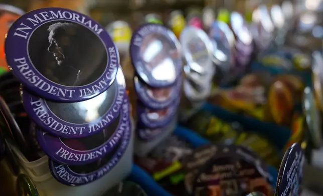 An In Memorium button for former President Jimmy Carter is seen inside the Plains Trading Post, Monday, Dec. 30, 2024, in Plains, Ga. Former President Jimmy Carter died Sunday at the age of 100. (AP Photo/Mike Stewart)