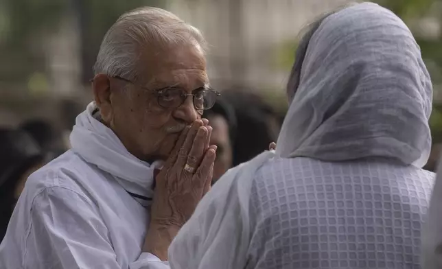 Indian film maker and poet Gulzar, left, pay homage to Shyam Benegal, a renowned Indian filmmaker who passed away on Monday, during Benegal's funeral in Mumbai, India, Tuesday, Dec. 24, 2024. (AP Photo/Rafiq Maqbool)