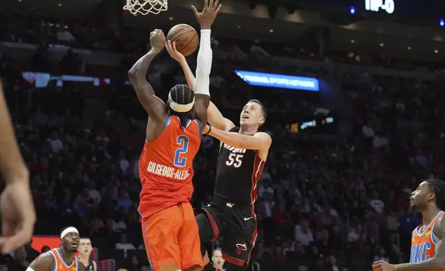 Miami Heat forward Duncan Robinson (55) drives to the basket as Oklahoma City Thunder guard Shai Gilgeous-Alexander (2) defends during the first half of an NBA basketball game, Friday, Dec. 20, 2024, in Miami. (AP Photo/Marta Lavandier)