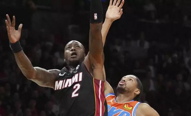 Miami Heat guard Terry Rozier (2) drives to the basket as Oklahoma City Thunder guard Aaron Wiggins (21) defends during the first half of an NBA basketball game, Friday, Dec. 20, 2024, in Miami. (AP Photo/Marta Lavandier)