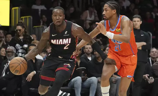 Oklahoma City Thunder guard Aaron Wiggins (21) defends Miami Heat guard Terry Rozier (2) during the first half of an NBA basketball game, Friday, Dec. 20, 2024, in Miami. (AP Photo/Marta Lavandier)