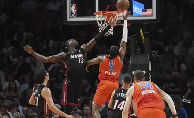 Oklahoma City Thunder forward Jalen Williams (8) drives to the basket as Miami Heat center Bam Adebayo (13) defends during the first half of an NBA basketball game, Friday, Dec. 20, 2024, in Miami. (AP Photo/Marta Lavandier)