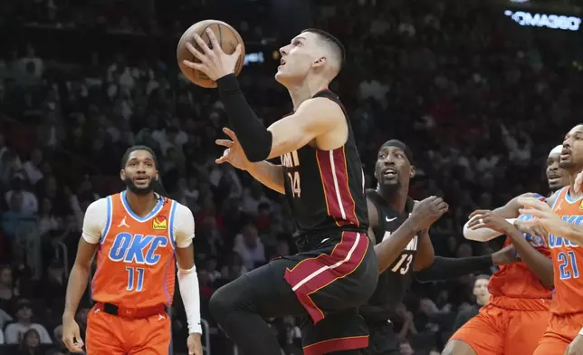 Miami Heat guard Tyler Herro (14) drives to the basket during the first half of an NBA basketball game against the Oklahoma City Thunder, Friday, Dec. 20, 2024, in Miami. (AP Photo/Marta Lavandier)