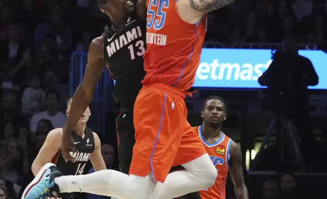 Oklahoma City Thunder center Isaiah Hartenstein (55) and Miami Heat center Bam Adebayo (13) go after a ball before it goes out of bounds during the first half of an NBA basketball game, Friday, Dec. 20, 2024, in Miami. (AP Photo/Marta Lavandier)