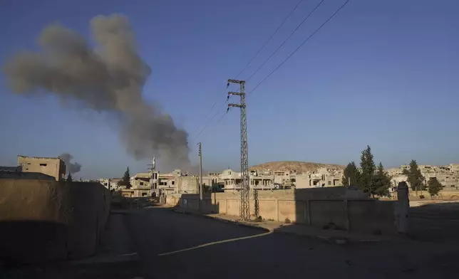 Smoke from an airstrike by government forces billows in the sky over the town of Khan Sheikhoun, south of Idlib, Syria, Tuesday, Dec. 3, 2024. (AP Photo/Omar Albam)