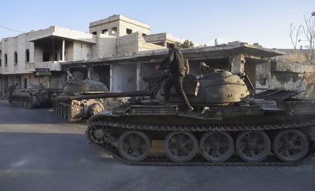 Syrian opposition fighters manoeuvre using armoured vehicles seized from the Syrian army in the town of Maarat al-Numan, south of Idlib, Syria, Tuesday Dec. 3, 2024.(AP Photo/Omar Albam)