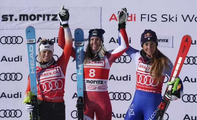 Austria's Cornelia Huetter, center, winner of an alpine ski, women's World Cup super G, celebrates on the podium with second-placed Switzerland's Lara Gut Behrami, left, and third-placed Italy's Sofia Goggia, in St. Moritz, Switzerland, Saturday, Dec. 21, 2024. (AP Photo/Giovanni Auletta)