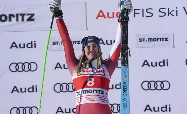 Austria's Cornelia Huetter celebrates on the podium after winning an alpine ski, women's World Cup super G, in St. Moritz, Switzerland, Saturday, Dec. 21, 2024. (AP Photo/Giovanni Auletta)